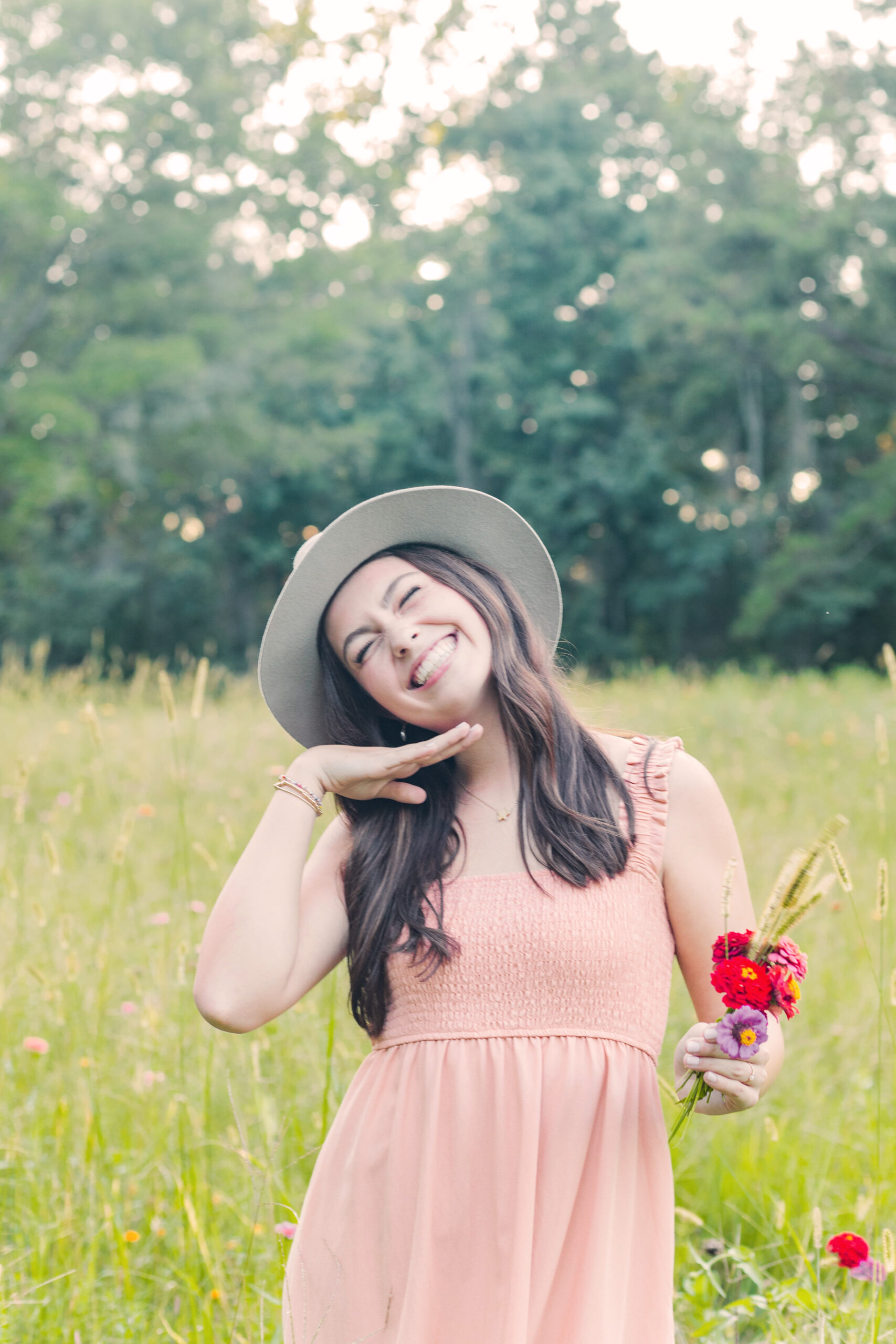 High school senior girl smiling in a field of flowers for senior portraits