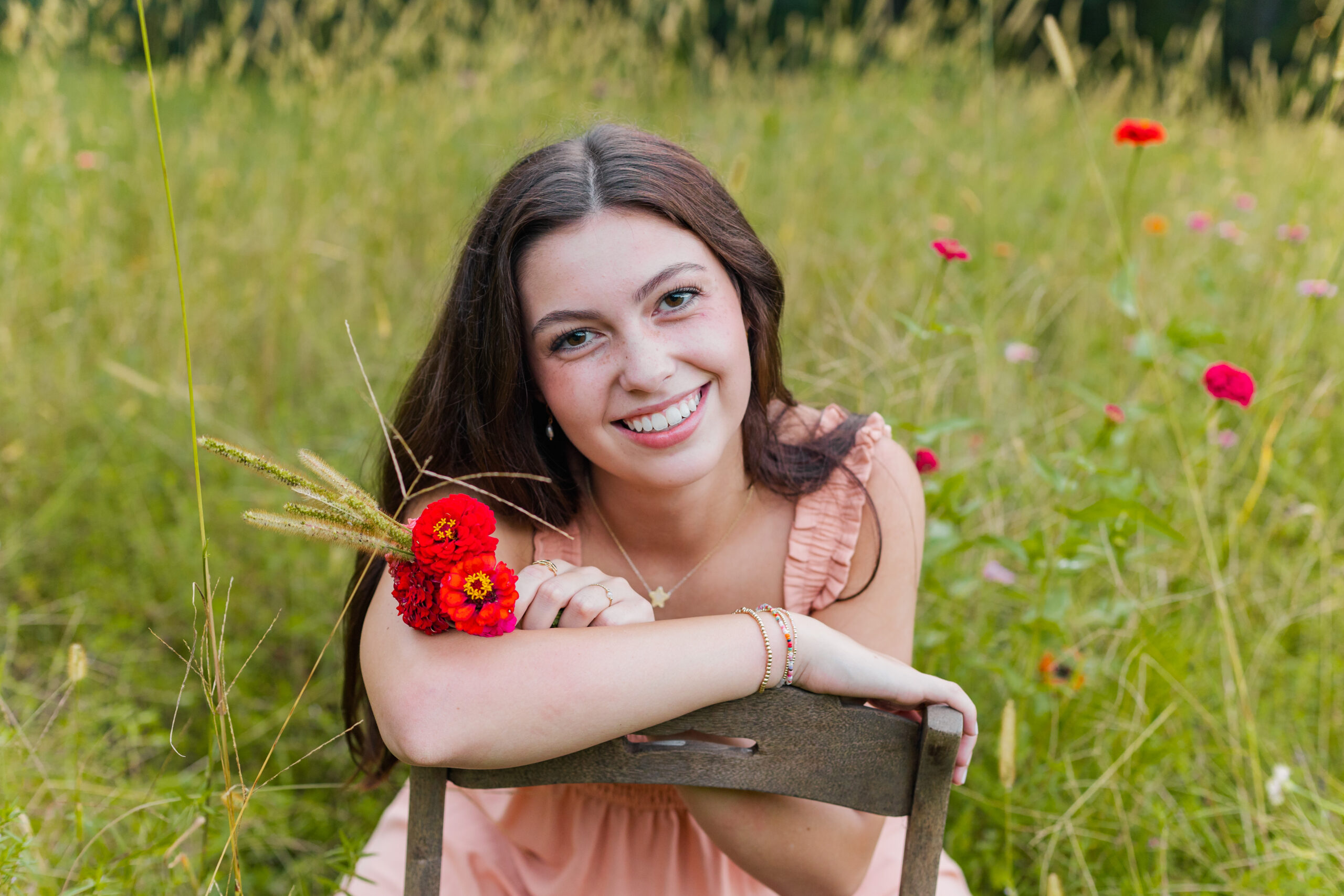 High School senior girl in a field with flowers for senior portraits