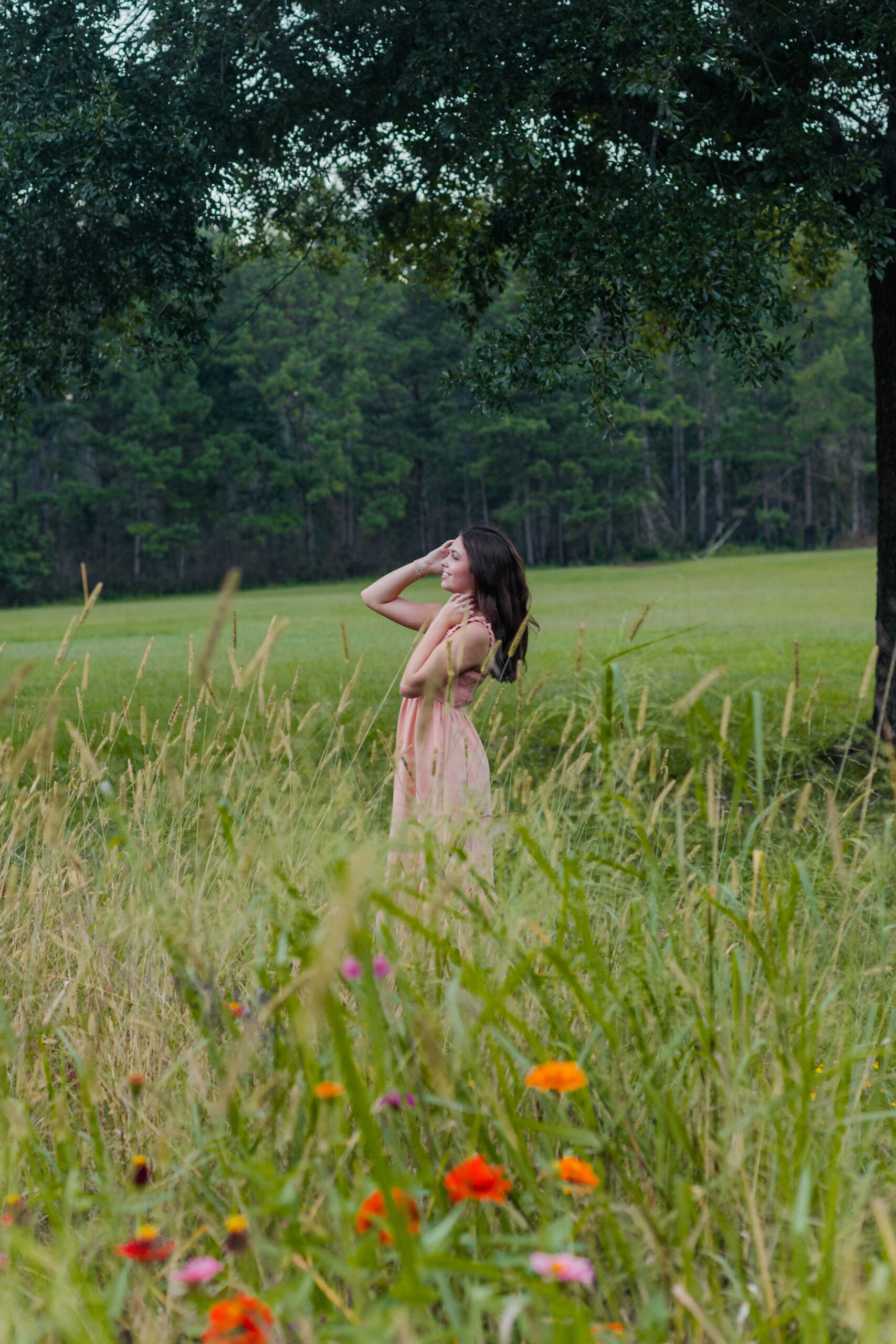 High School Senior girl in a field under a tree for senior portraits