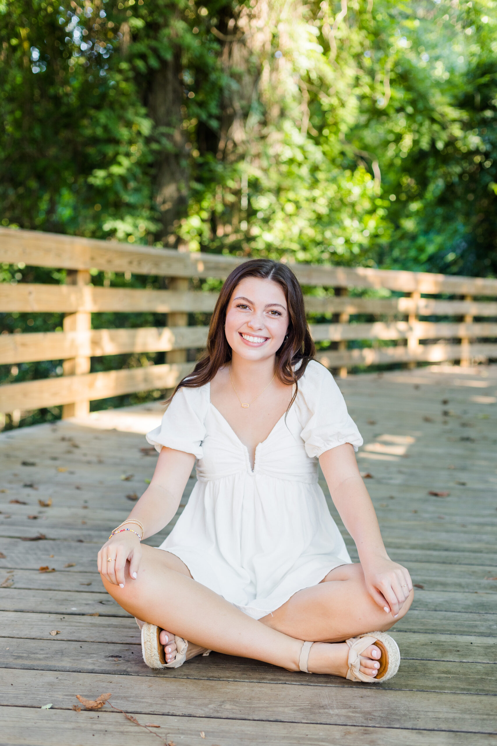 High School senior girl sitting on a bridge for senior portraits