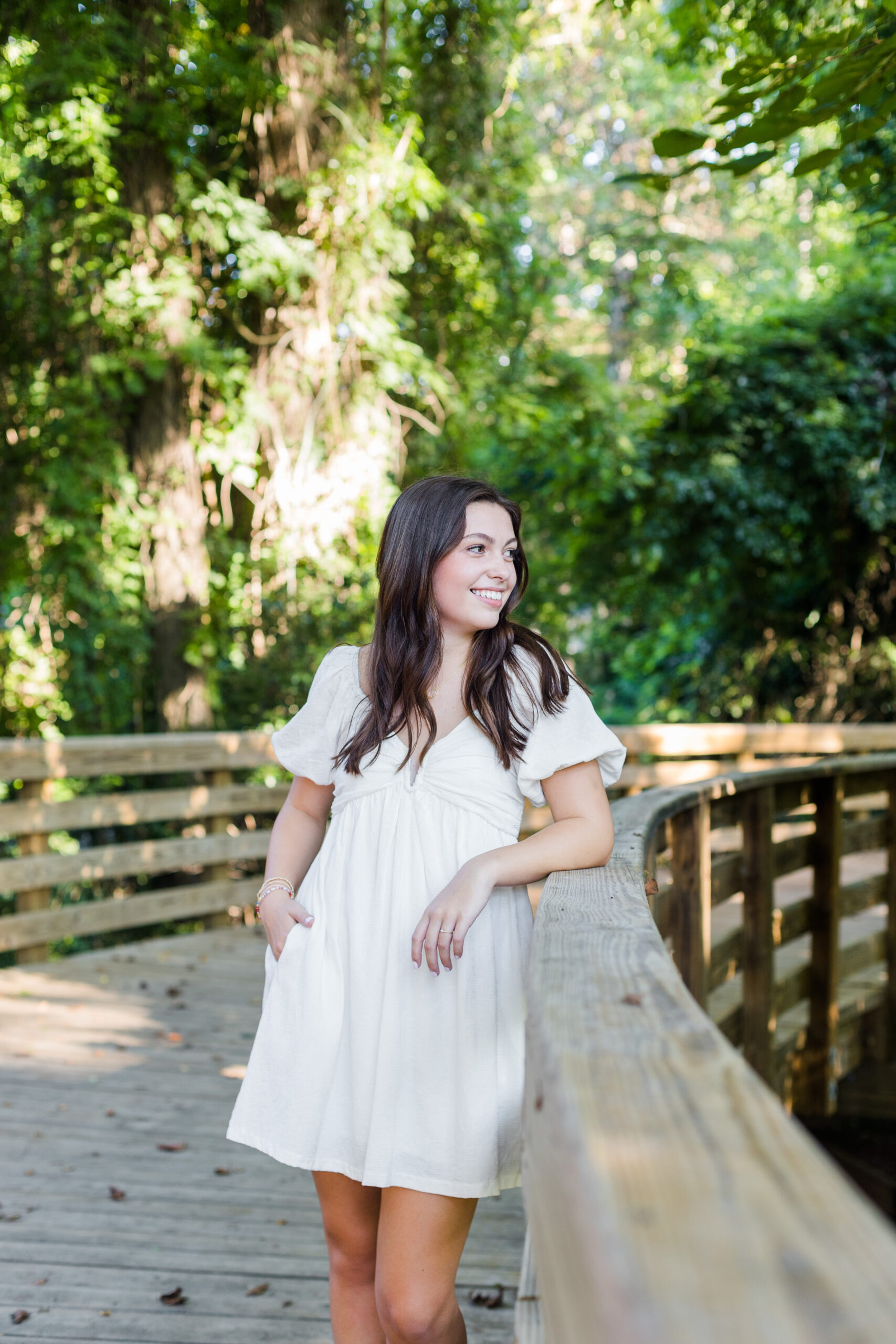 High school senior girl posing on a bridge looking over her shoulder