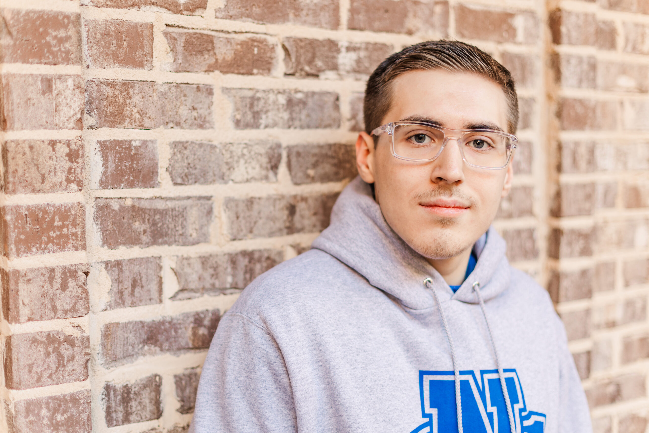 high school senior in front of brick wall